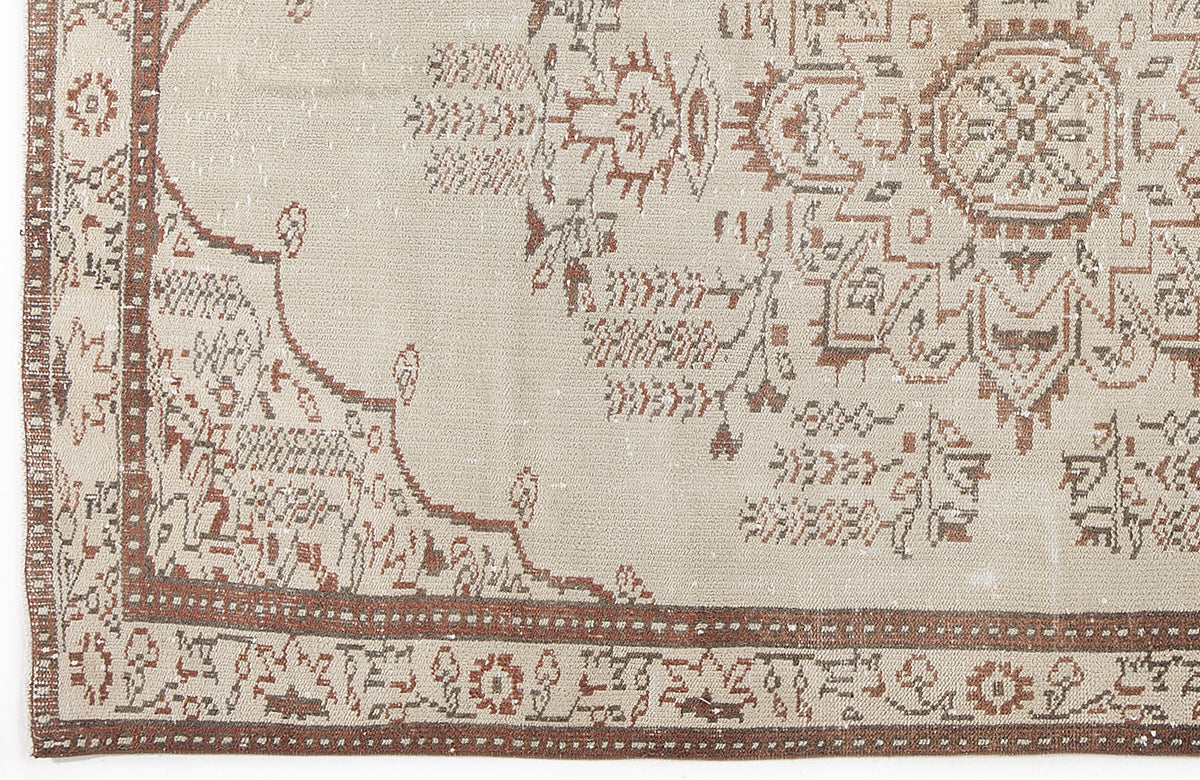 Beige and brown vintage-style rug with a central medallion and intricate geometric border pattern.