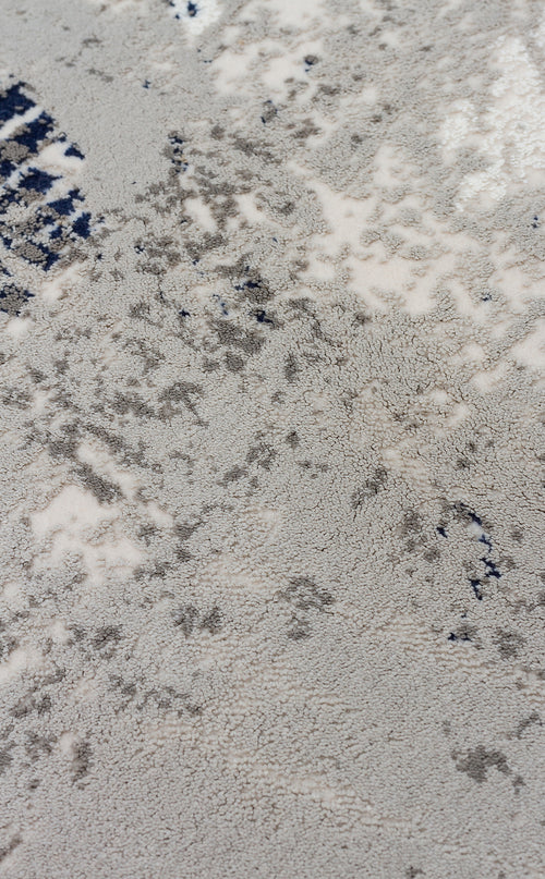 Load image 1 in gallery view. Close-up of a high-pile rug with a distressed, abstract pattern in shades of grey, cream, and navy blue.
