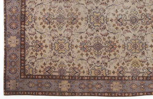 Load image 1 in gallery view. Beige, brown, and muted purple traditional rug with a repeating floral medallion pattern and a decorative border.