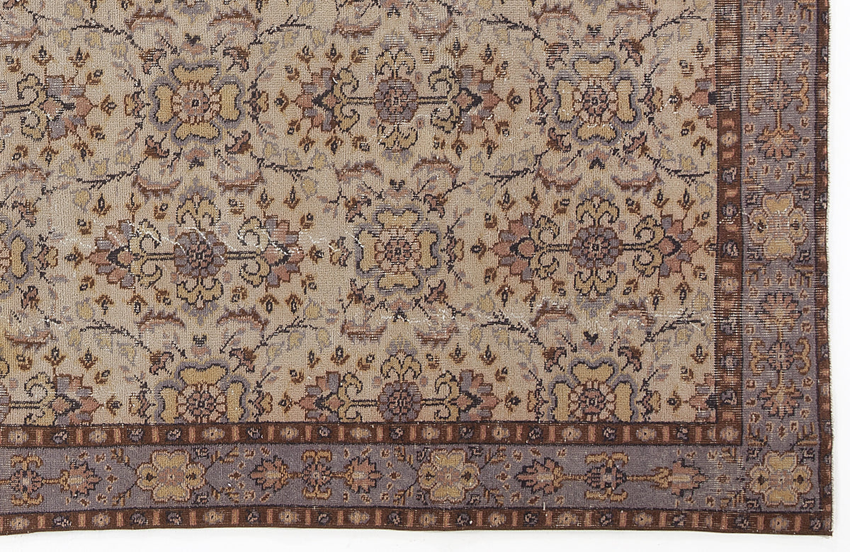 Beige and grey traditional rug with a distressed floral medallion pattern and a dark brown geometric border.