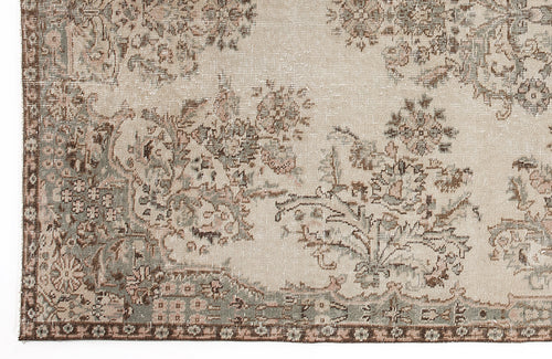 Load image 1 in gallery view. Beige rug with a distressed floral pattern in muted sage green and brown tones.