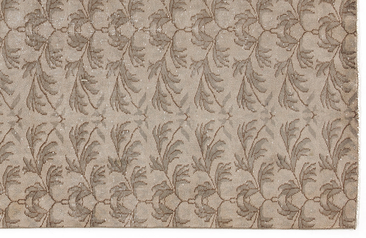 Taupe and beige rug featuring a repeating vertical botanical leaf pattern with a distressed texture.