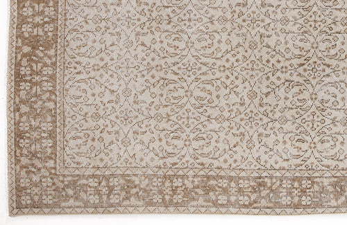Load image 1 in gallery view. Beige and tan rug with a distressed traditional floral vine pattern and a wide decorative border.