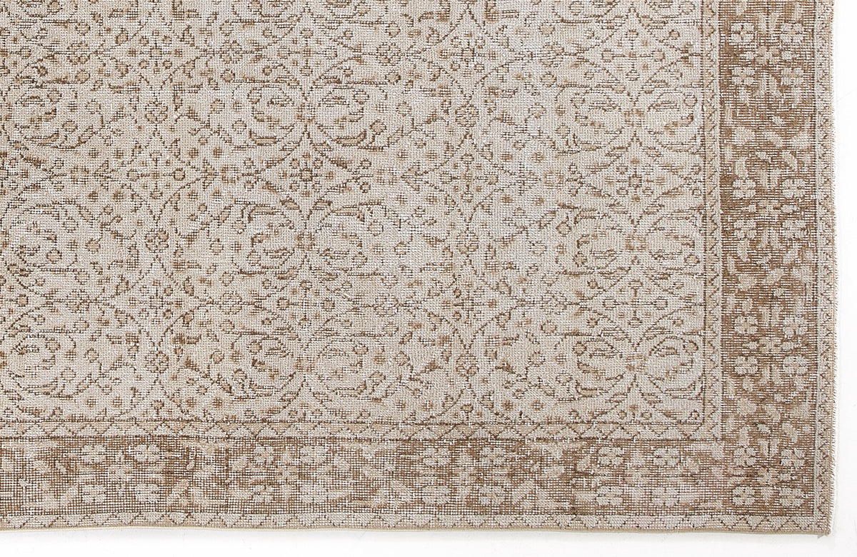 Beige and cream rug with a traditional floral lattice pattern and a wide decorative border.