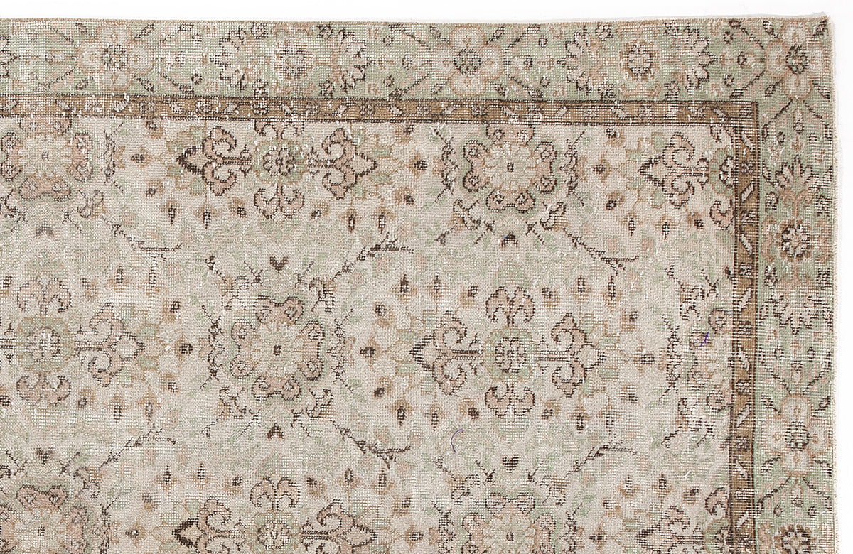 Sage green and beige vintage-style rug with a traditional floral medallion pattern and a decorative border.