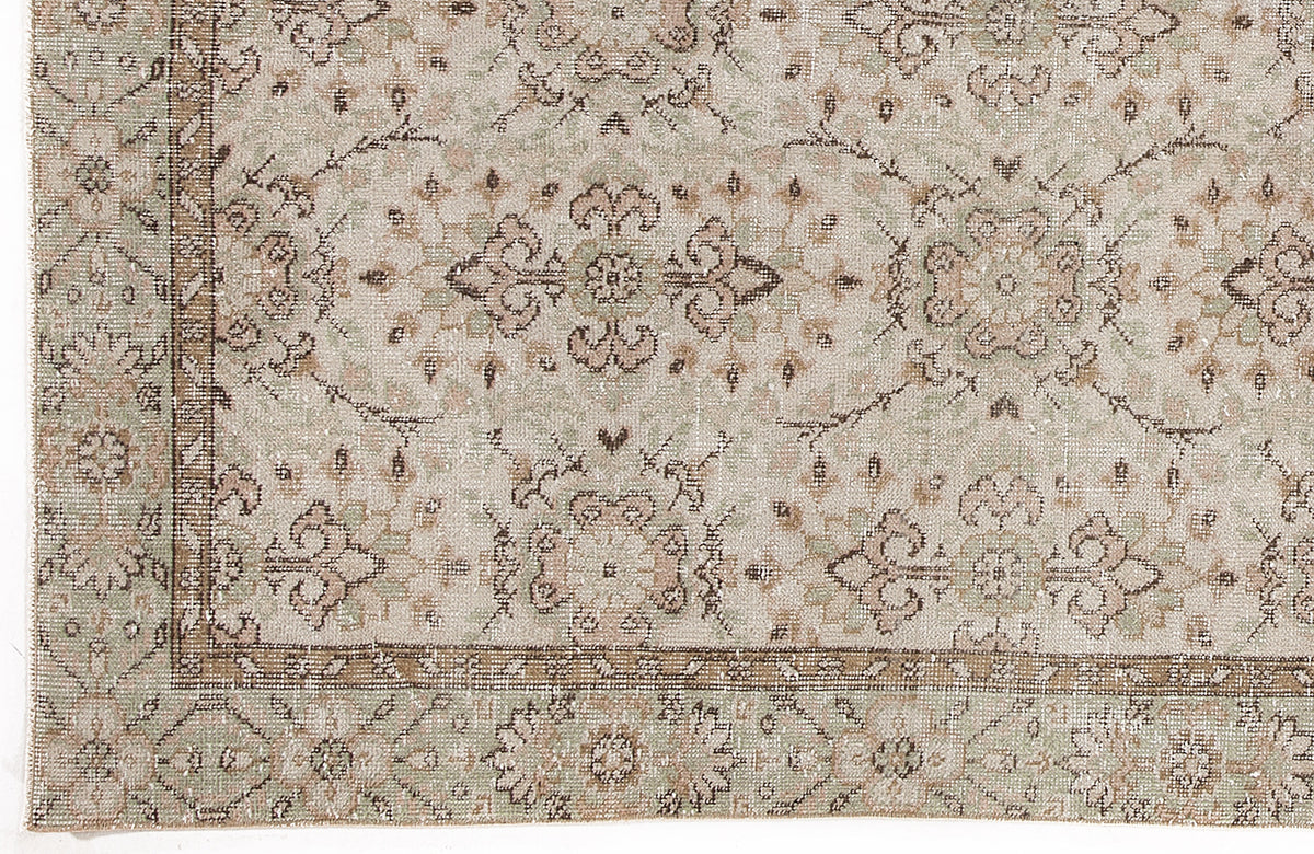 Beige, sage green, and brown traditional rug with a distressed floral medallion pattern and a decorative border.