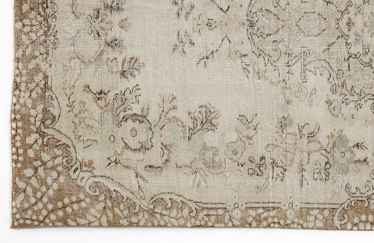Beige and taupe vintage-style rug with a distressed floral medallion pattern and ornate border.