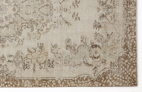 Load image 1 in gallery view. Beige and brown vintage-style rug with a faded floral medallion pattern and a decorative border.