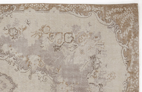 Load image 1 in gallery view. Beige and taupe distressed rug with a faded traditional floral medallion pattern.