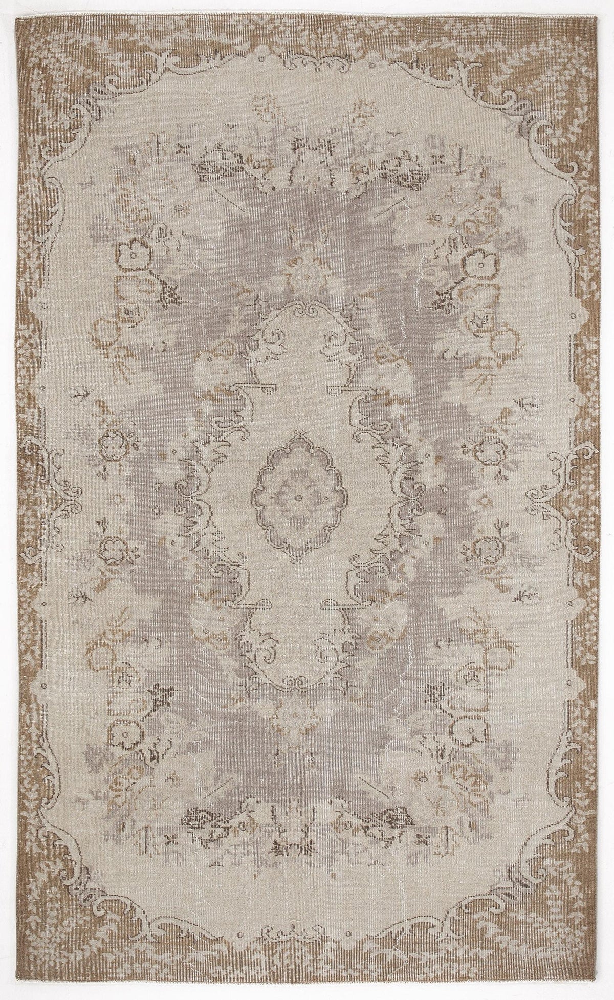 Taupe and cream distressed traditional rug with a central floral medallion and ornate border.