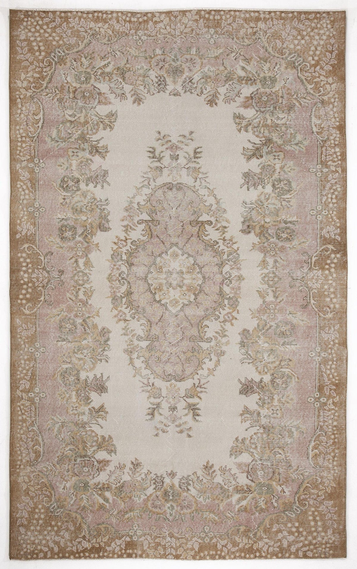 Beige and dusty pink traditional rug with a central floral medallion and ornate border on a white background.