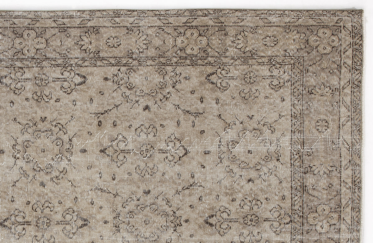 Taupe and charcoal distressed rug with a traditional floral medallion border and central motif.