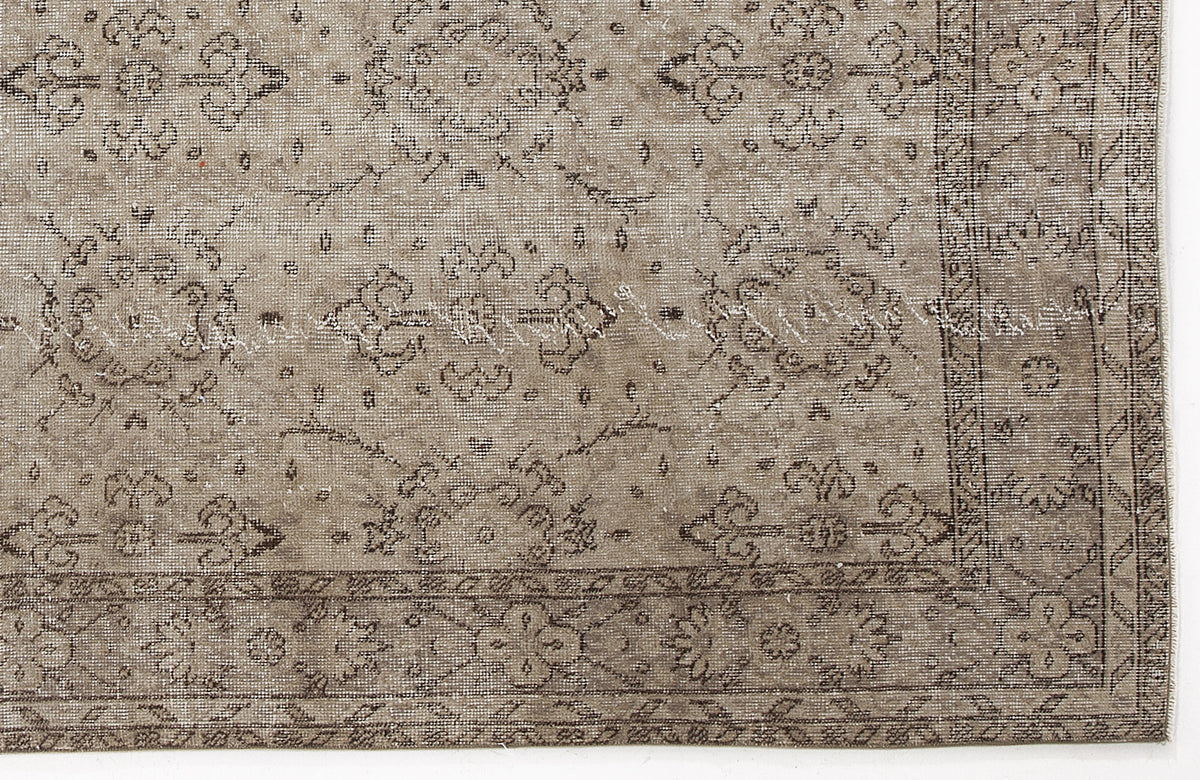 Taupe and brown distressed rug with a traditional floral medallion pattern and a detailed border.
