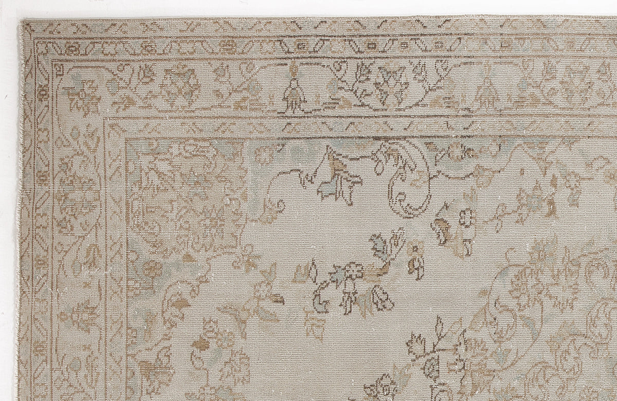 Beige and light blue traditional rug with a distressed floral medallion pattern and a detailed border.