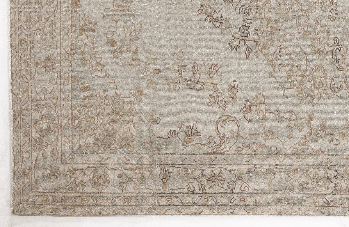 Light beige and taupe rug with a distressed traditional floral medallion pattern and a detailed border.