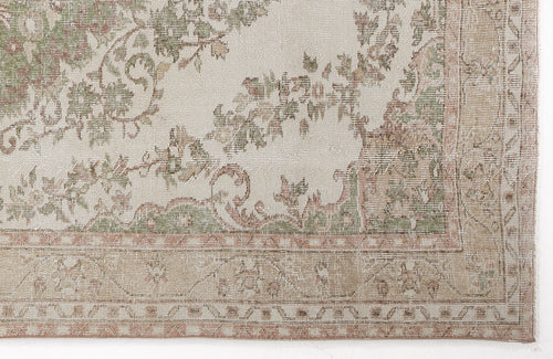 Load image 1 in gallery view. Cream rug with a distressed floral medallion pattern in sage green and muted terracotta, featuring a geometric border.