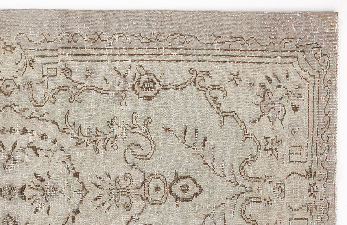 Beige and taupe vintage-style rug with a distressed floral medallion pattern and a decorative border.