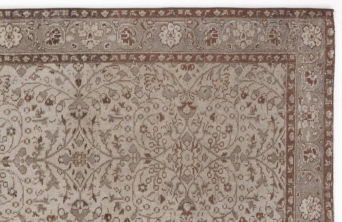 Taupe and brown traditional rug with a detailed floral medallion pattern and a decorative border.