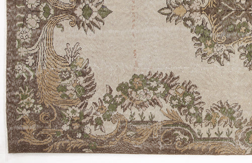 Load image 1 in gallery view. Beige vintage-style rug with a distressed brown and green floral medallion pattern.