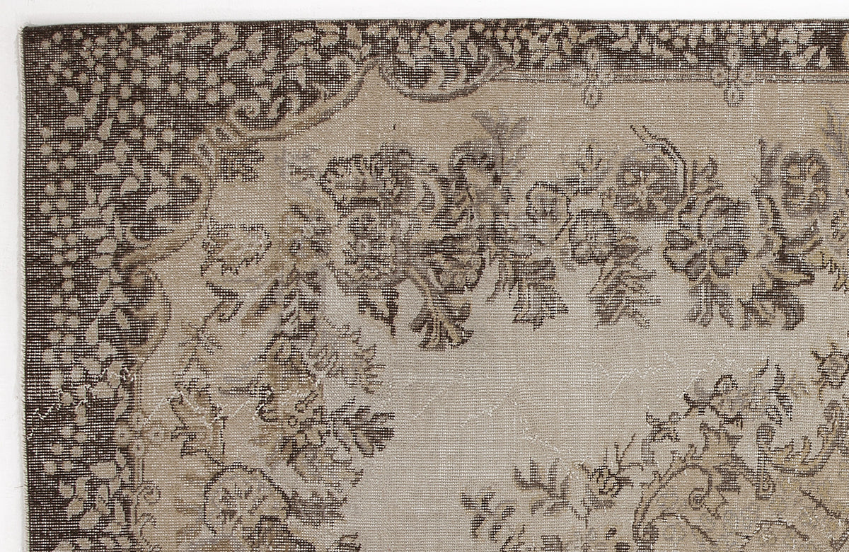 Dark brown and beige rug with a distressed floral medallion pattern and a decorative border.