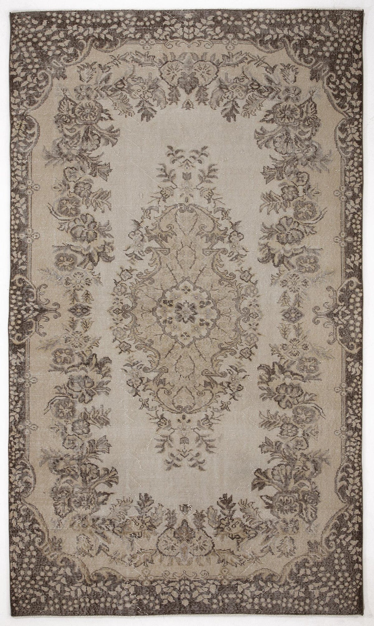 Beige and dark brown traditional rug with a central floral medallion and ornate botanical border.