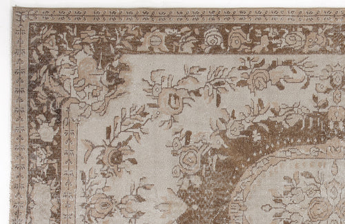 Load image 1 in gallery view. Beige and brown traditional rug with a distressed floral medallion pattern and ornate border.