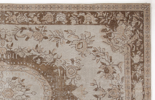 Load image 1 in gallery view. Beige and brown distressed rug with a traditional floral medallion pattern and ornate border.