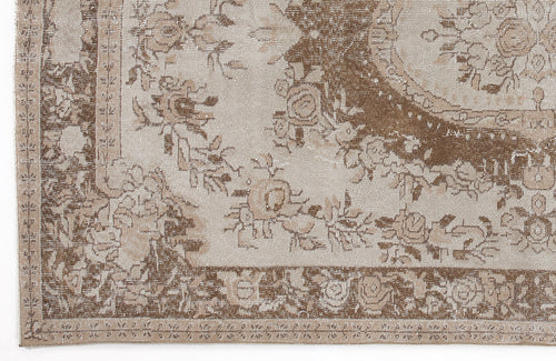 Load image 1 in gallery view. Beige and brown vintage-style rug with a distressed floral medallion pattern and a decorative border.