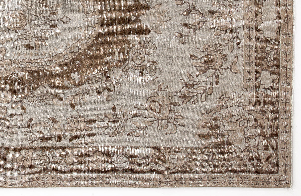 Beige and brown distressed rug with a traditional floral medallion pattern and ornate border.