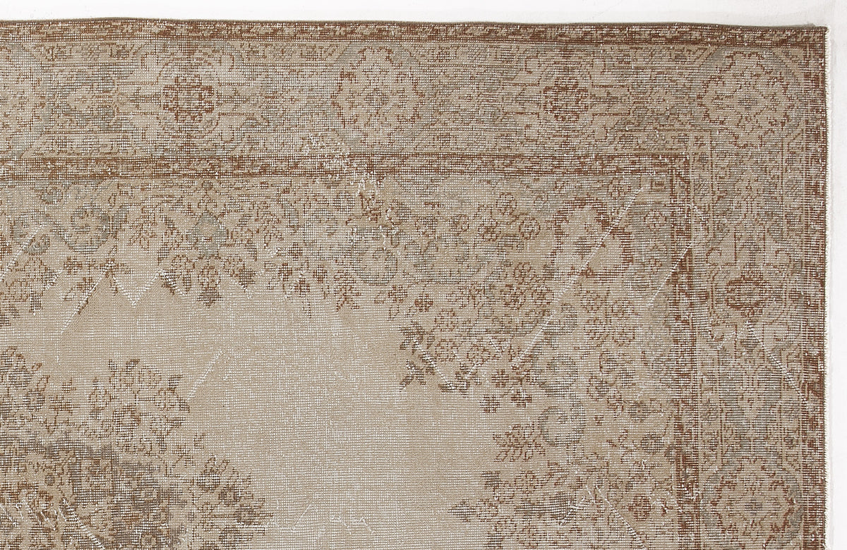 Tan and brown traditional rug with a distressed floral medallion pattern and a detailed border.