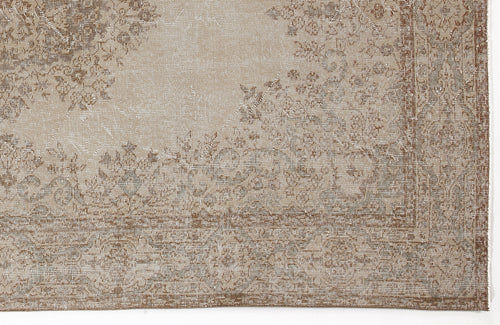 Load image 1 in gallery view. Beige and brown distressed traditional rug with a faded floral medallion pattern.