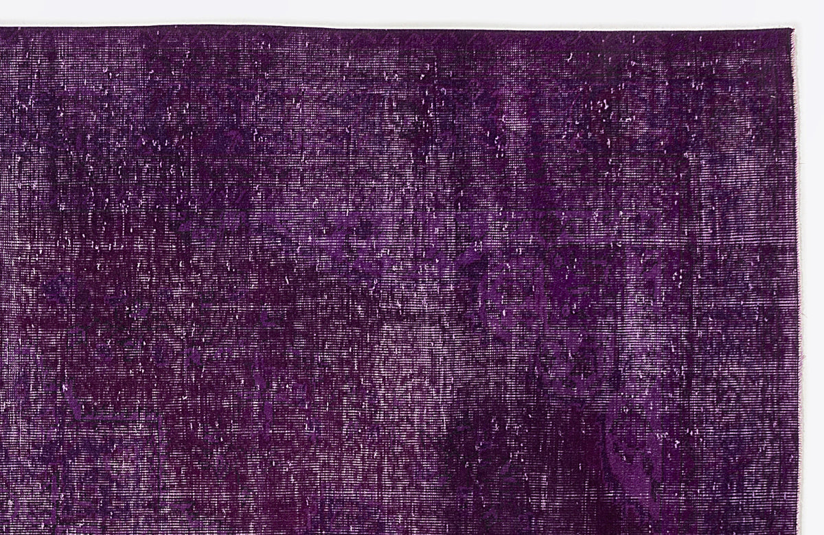 Deep purple vintage-style rug with a distressed, overdyed texture and faint traditional medallion pattern.