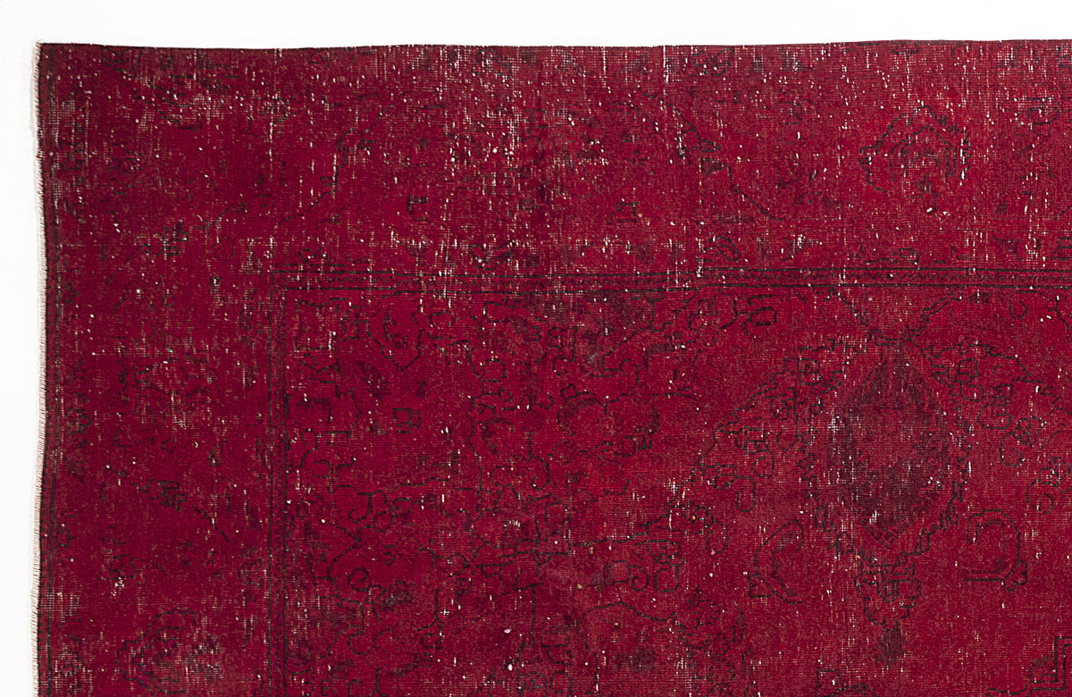 Deep red vintage-style rug with a distressed, faded black floral medallion pattern and white worn detailing.