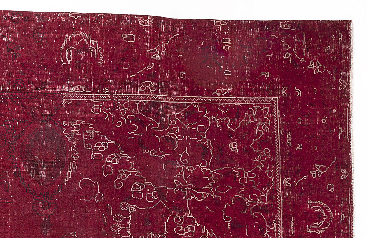 Deep red vintage-style rug with a distressed, white linear geometric pattern and a bordered medallion design.