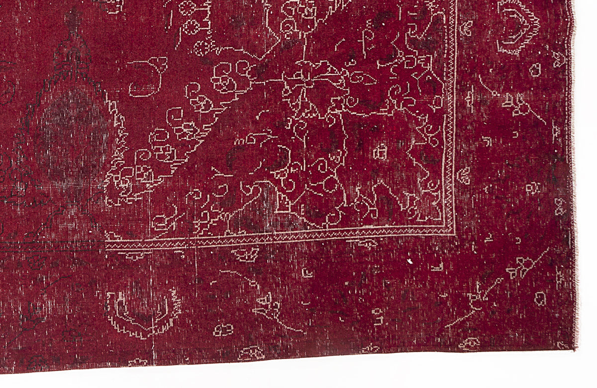 Deep red vintage-style rug with a distressed white linear floral and geometric border pattern on a white background.