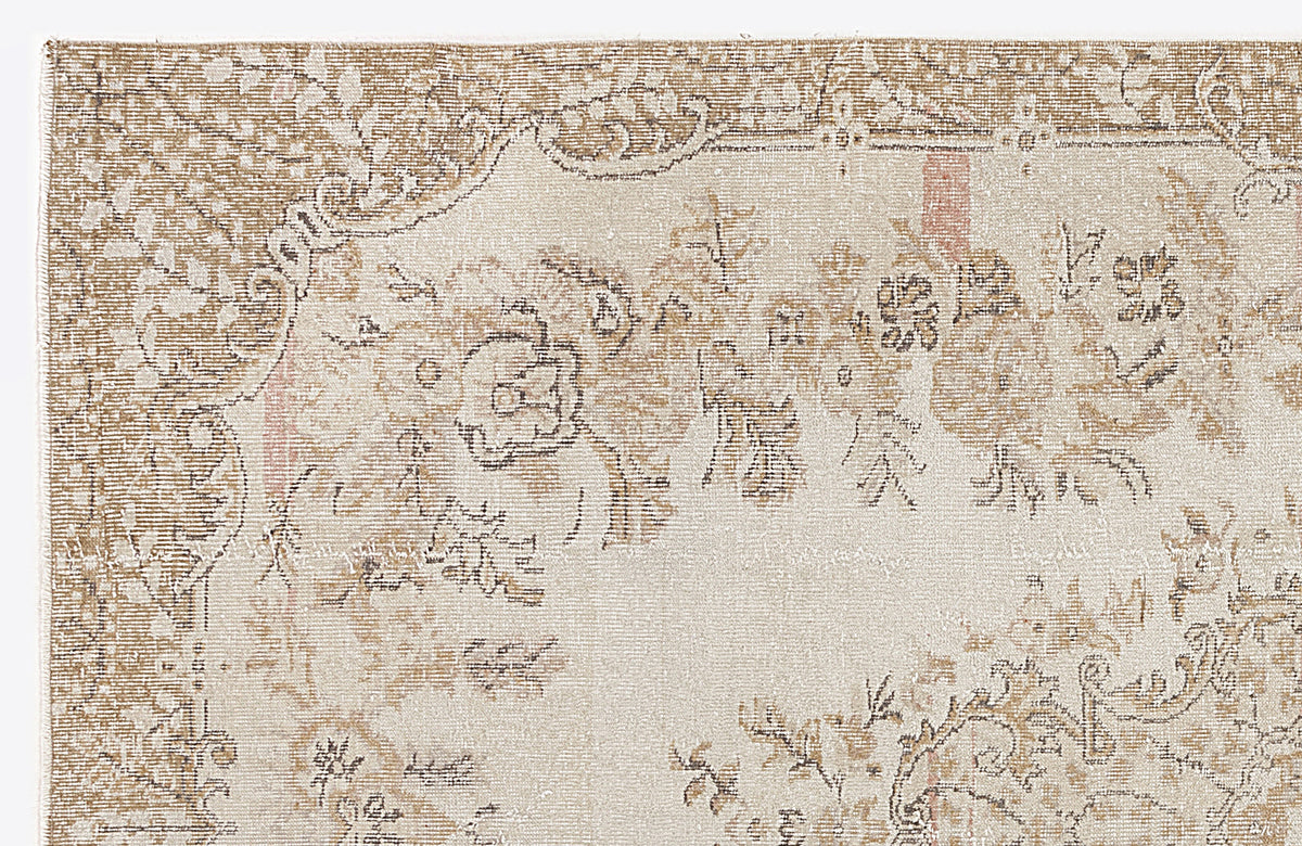 Beige and cream vintage-style rug with a distressed floral medallion pattern.