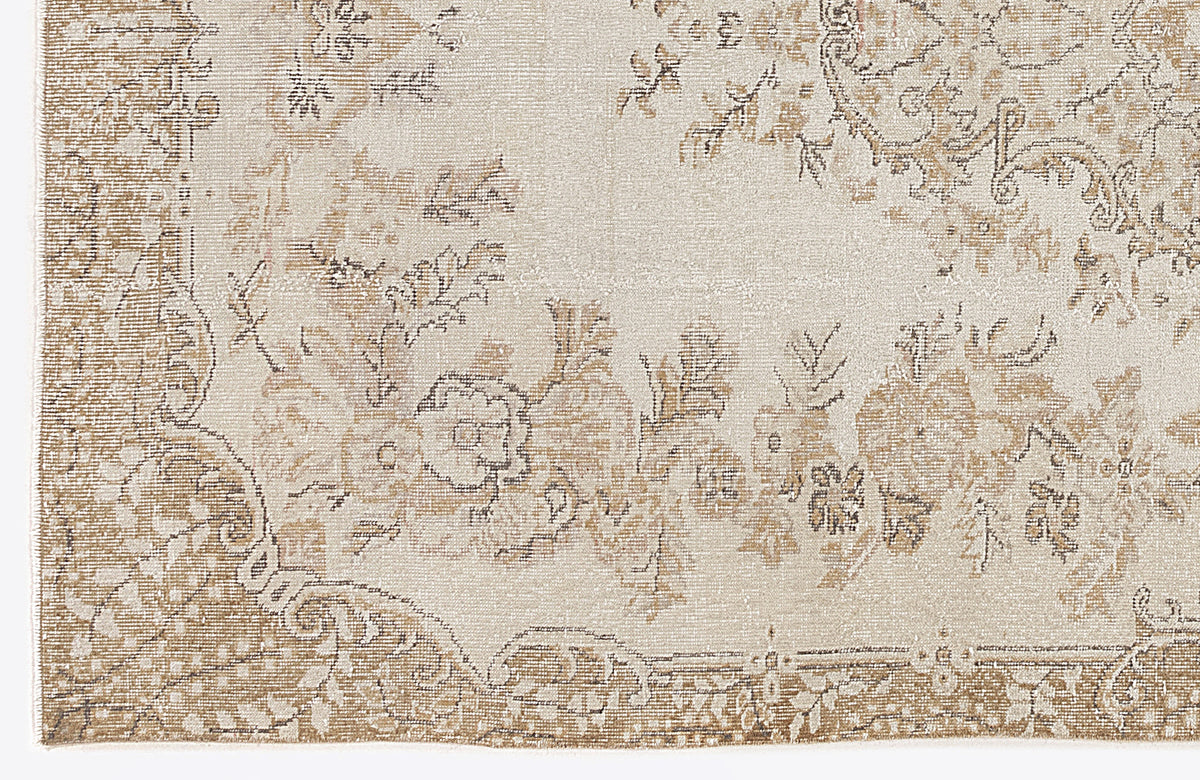 Beige and cream rug with a distressed traditional floral medallion pattern.