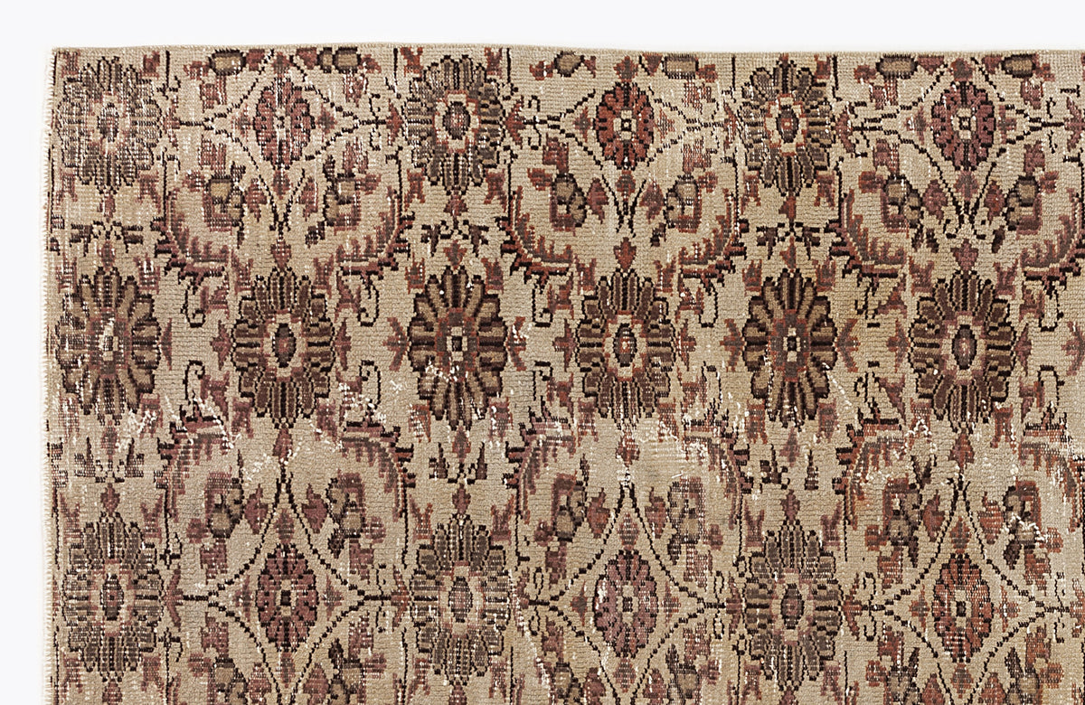 Beige and brown vintage-style rug with a repeating floral medallion pattern and distressed texture.