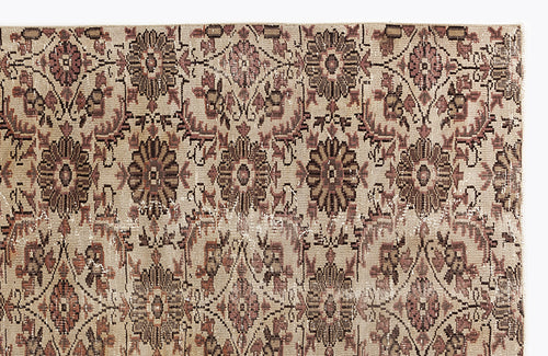 Load image 1 in gallery view. Beige rug with a repeating floral medallion pattern in muted brown and dusty rose, featuring a distressed texture.