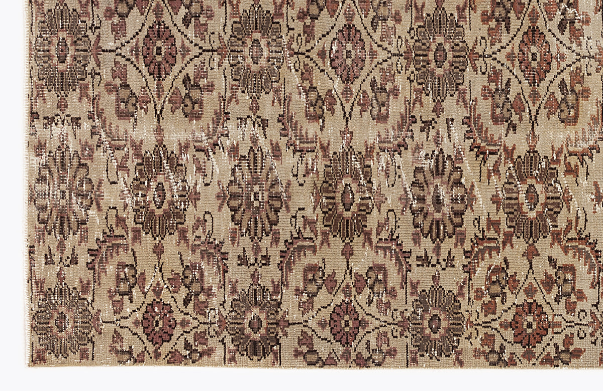 Beige and brown distressed rug with a repeating floral medallion pattern in a grid layout.