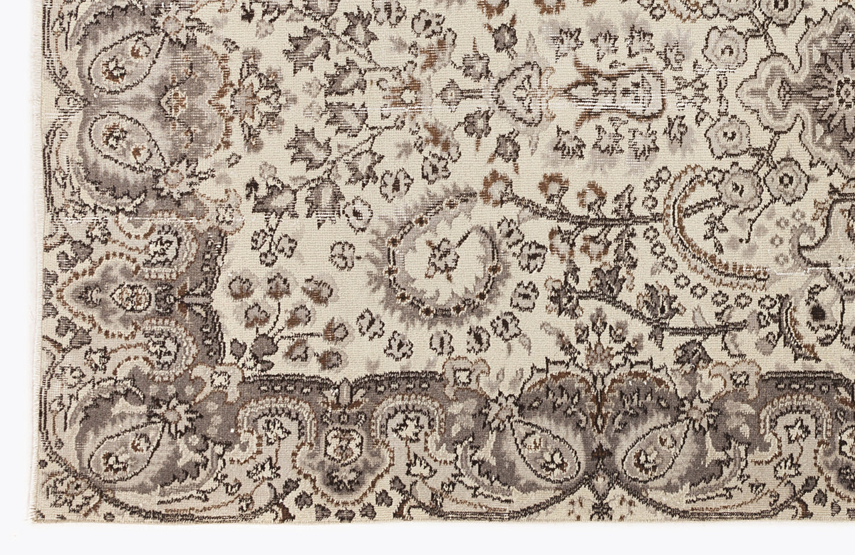 Cream, taupe, and brown rug with a distressed traditional Persian-style floral medallion pattern.