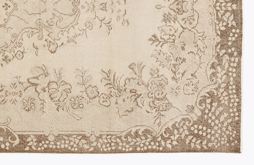 Load image 1 in gallery view. Beige and brown rug with a distressed floral pattern and a decorative border.