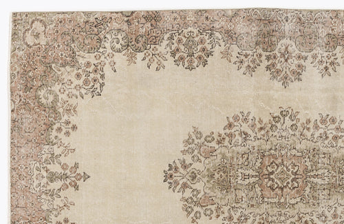 Load image 1 in gallery view. Beige rug with a distressed floral medallion pattern in muted terracotta and sage green.