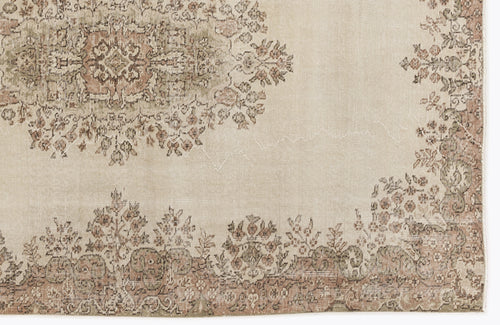 Load image 1 in gallery view. Beige rug with a distressed floral medallion and border pattern in muted sage green and dusty rose.