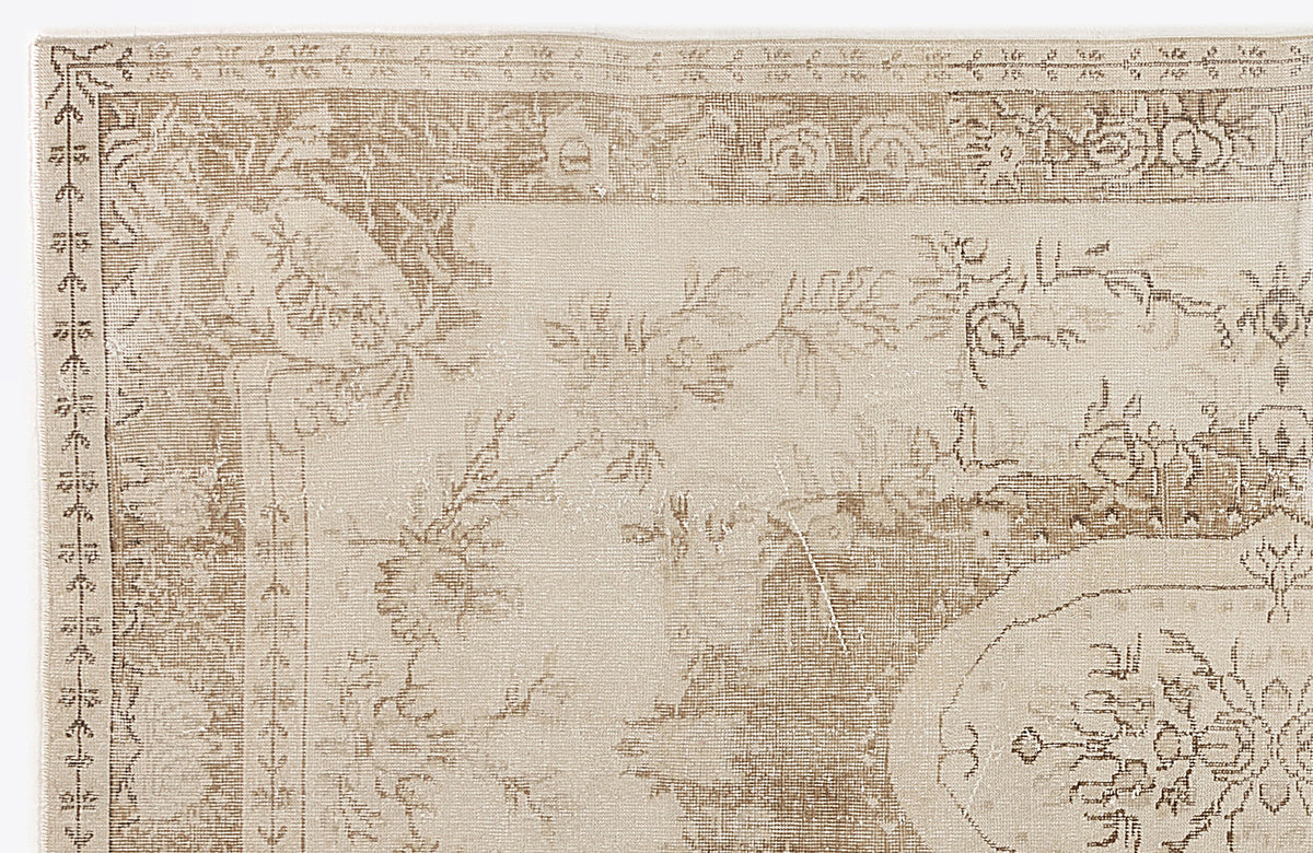 Beige and cream traditional rug with a distressed floral medallion pattern and ornate border.