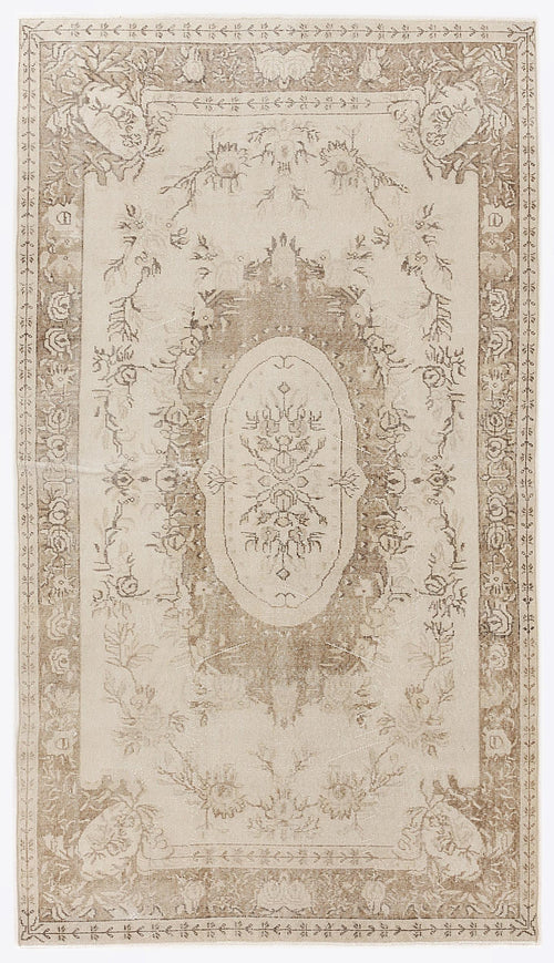 Load image 1 in gallery view. Beige and cream vintage-style rug with a central floral medallion and ornate botanical border.