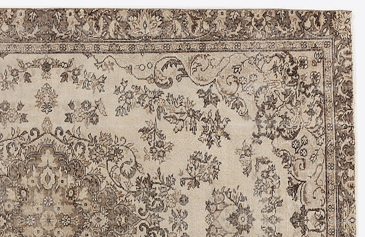 Beige and brown traditional rug with a distressed floral medallion pattern and ornate border.