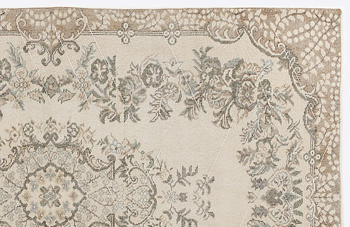 Load image 1 in gallery view. Beige and taupe traditional rug with a distressed floral medallion pattern and a subtle white geometric grid overlay.