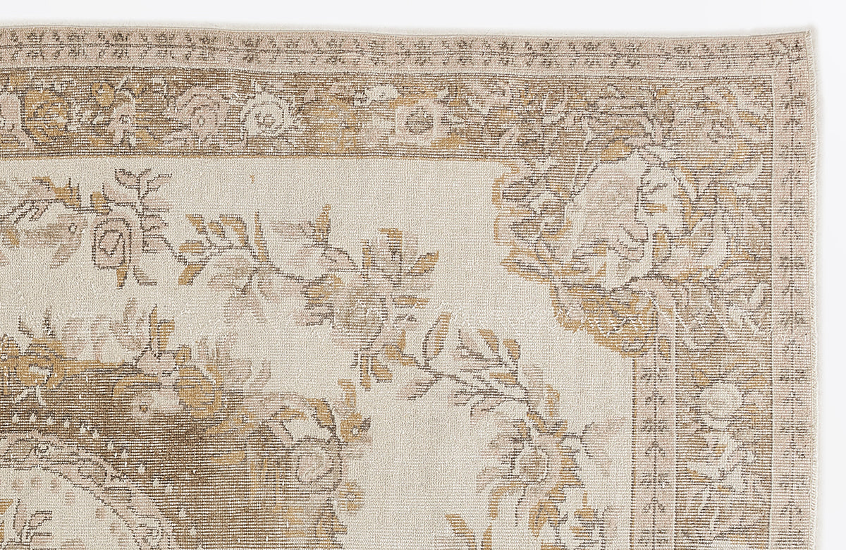Cream and beige rug with a traditional floral medallion pattern and a decorative border on a white background.