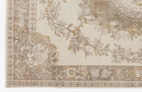 Load image 1 in gallery view. Beige and tan rug with a distressed floral medallion pattern and a decorative border.